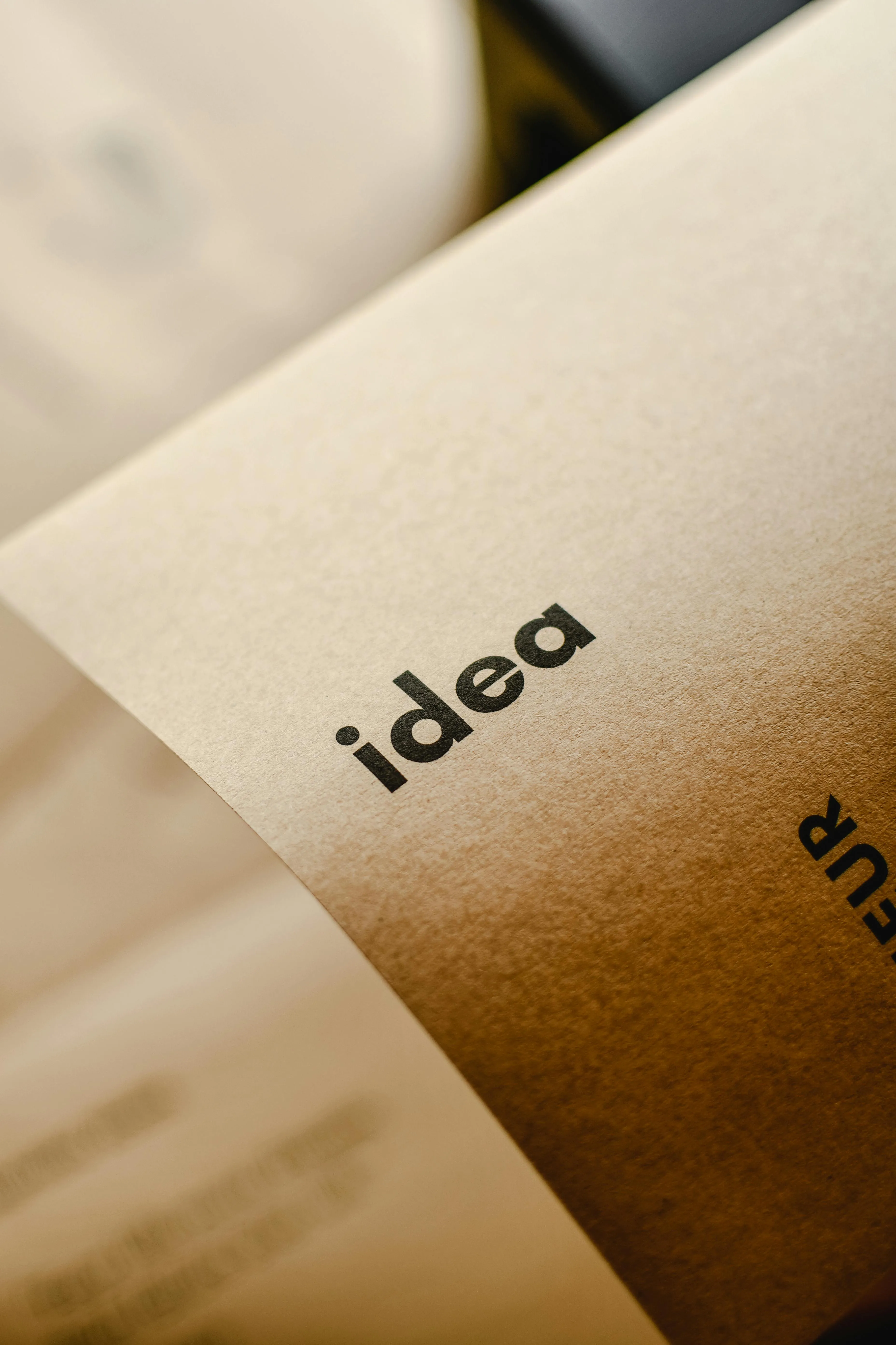 Sticky note reading "Idea" pinned to brown paper